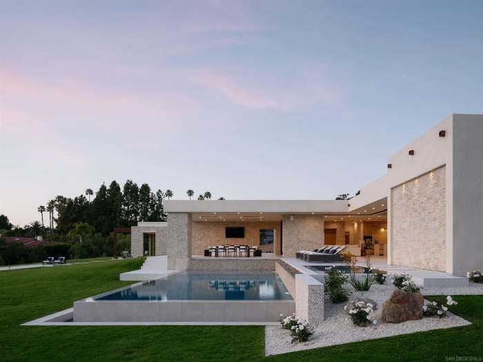 The estate at pink dusk with infinity pool and lawn