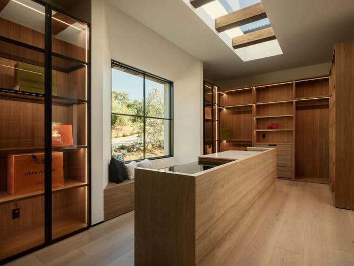 Walk-in dressing room with skylight and glass display cabinets