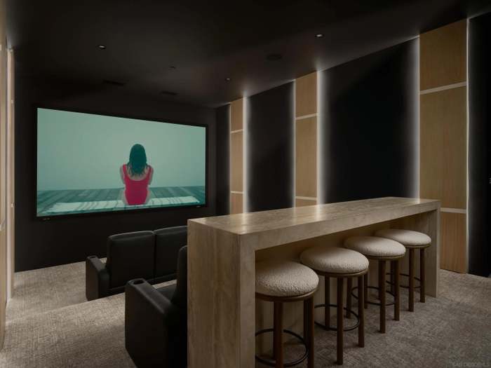 Private home theater with travertine bar seating