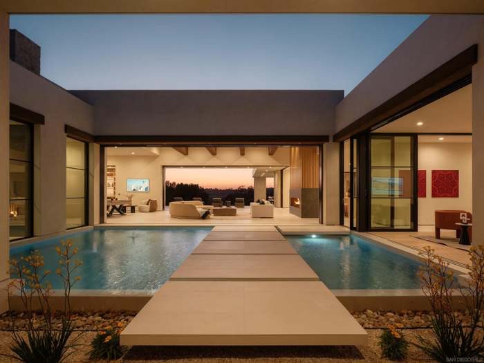 Main entrance courtyard with twin reflection pools and stone water walkway at dusk